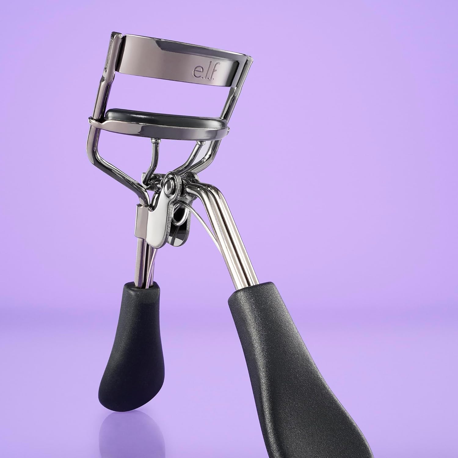 Close view of the e.l.f. Pro Eyelash Curler showing the spring behind the hinge and the e.l.f. logo embossed on the clamp bar