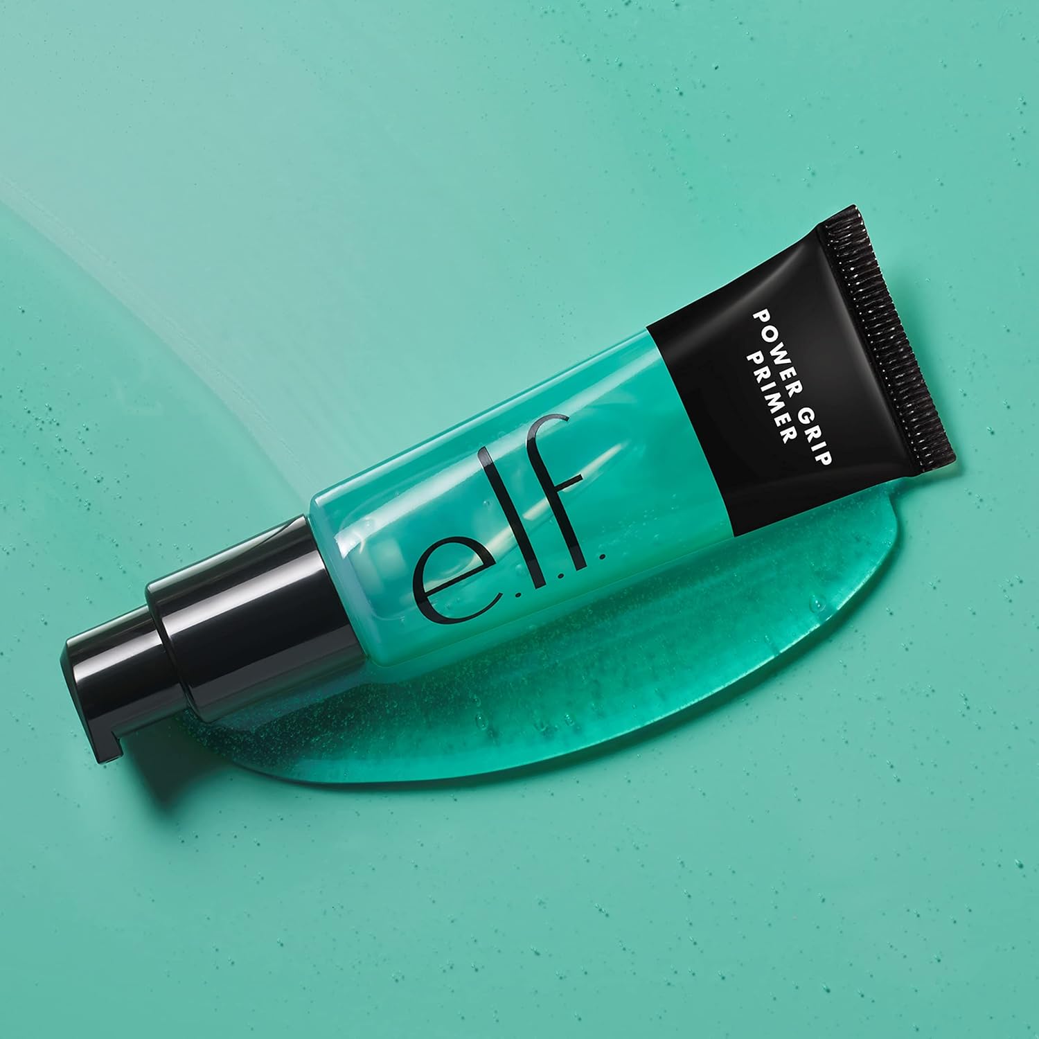 e.l.f. Power Grip Primer tube lying on a swatch of the clear blue-green gel formula