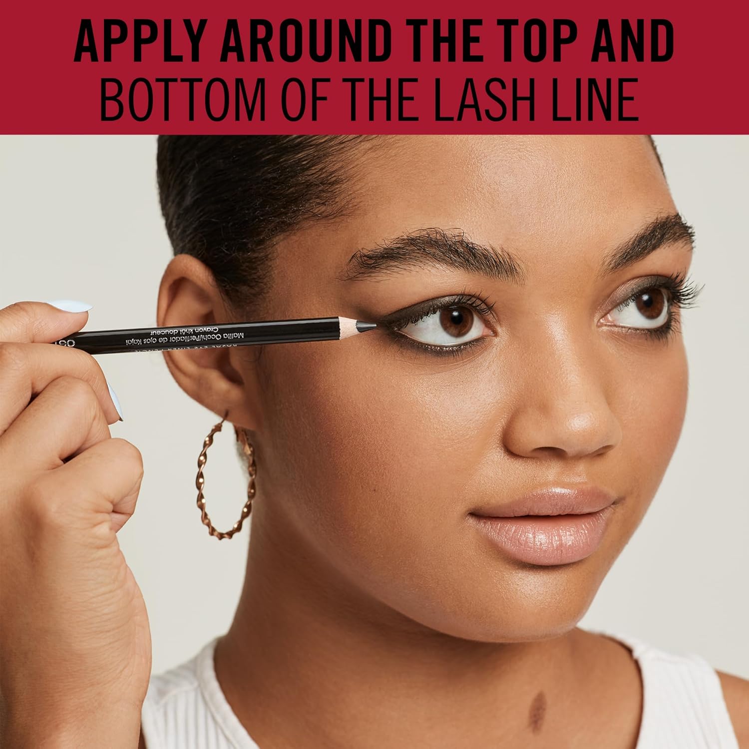 Model applying Rimmel Soft Kohl pencil along the upper lash line showing application technique