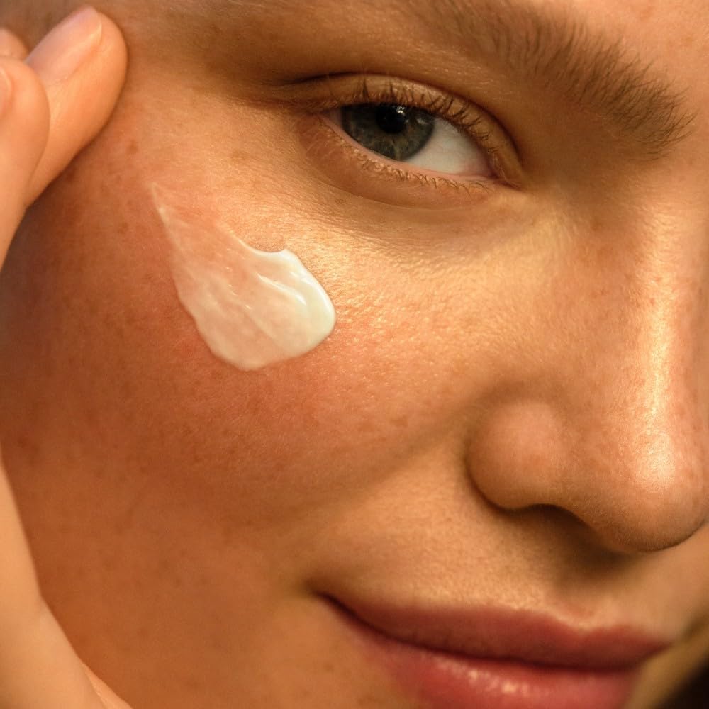 Weleda Skin Food cream being applied to face in a close-up showing the rich texture