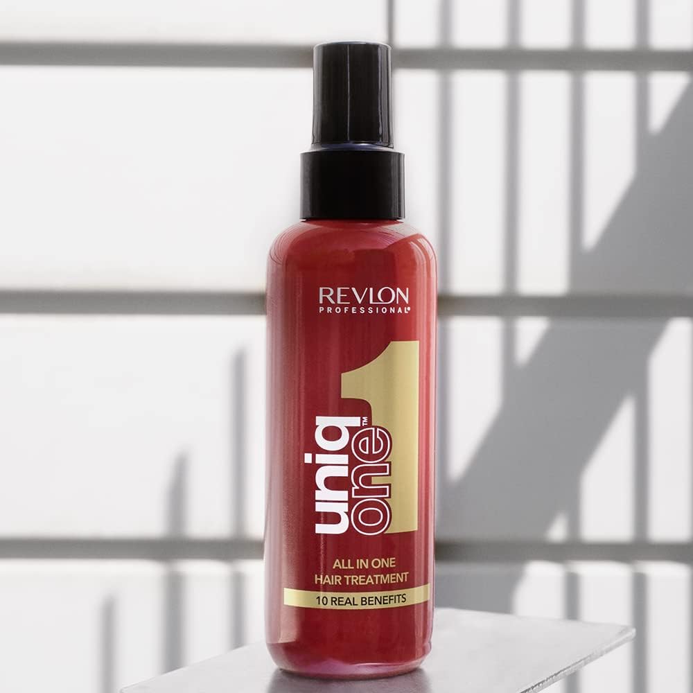 Woman applying Revlon UniqOne leave-in treatment to freshly washed hair
