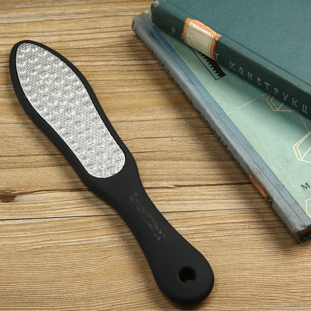 BEZOX foot file resting on a wooden surface beside a hardback book, showing the coarse steel face and the embossed bezox logo on the black handle