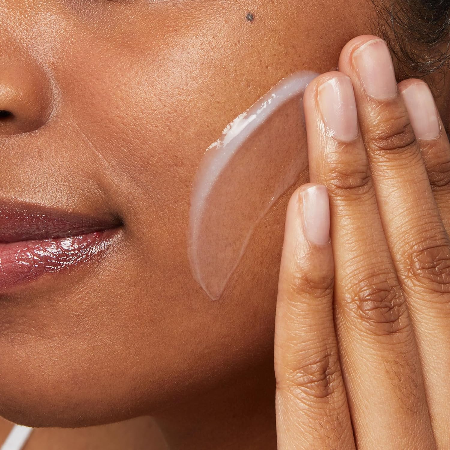 Woman applying CeraVe Hydrating Cleanser to her face showing the creamy non-foaming texture