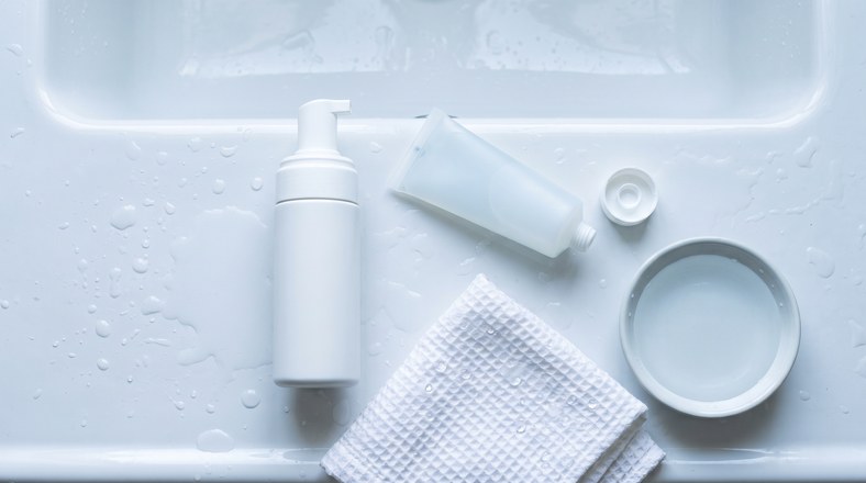 Foaming cleanser and light gel moisturiser on a basin edge for prepping oily skin before foundation