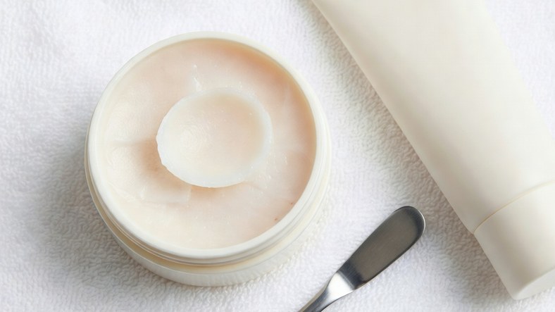 Open cleansing balm jar with spatula and tube alternative showing texture and packaging choices when buying a cleansing balm
