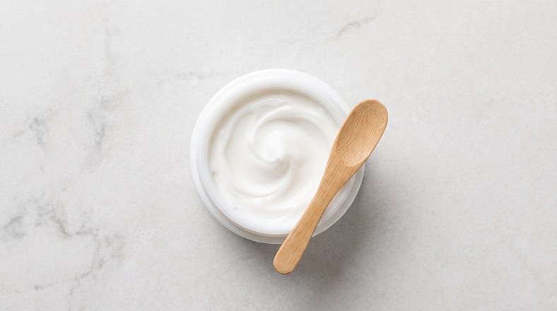 Open tub of moisturising cream, the moisturiser step in layering skincare in the right order
